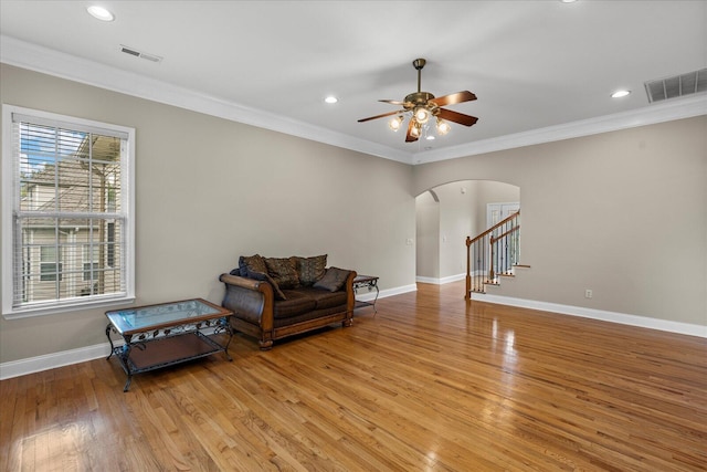 living room featuring ceiling fan, light hardwood / wood-style floors, and crown molding