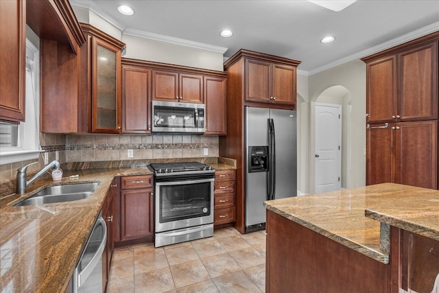 kitchen with backsplash, crown molding, sink, dark stone countertops, and stainless steel appliances