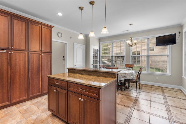 kitchen featuring a kitchen island, hanging light fixtures, ornamental molding, and light stone counters