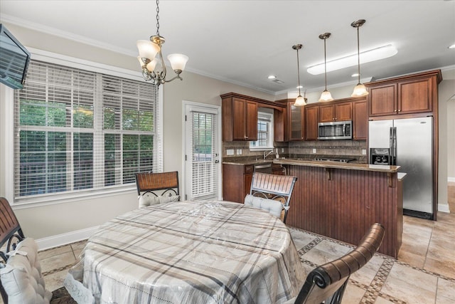 interior space featuring backsplash, stainless steel appliances, an inviting chandelier, and crown molding