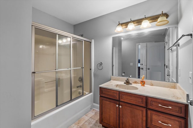 bathroom with tile patterned floors, vanity, and bath / shower combo with glass door