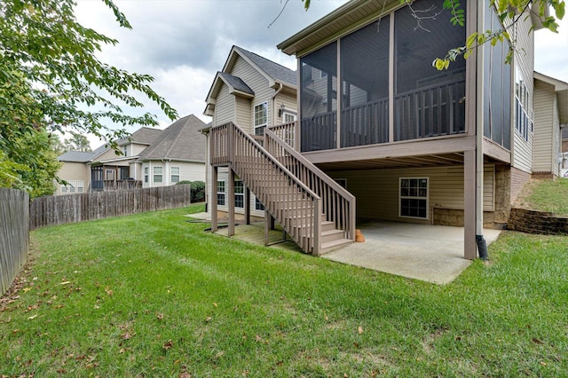 back of property with a patio, a lawn, and a sunroom