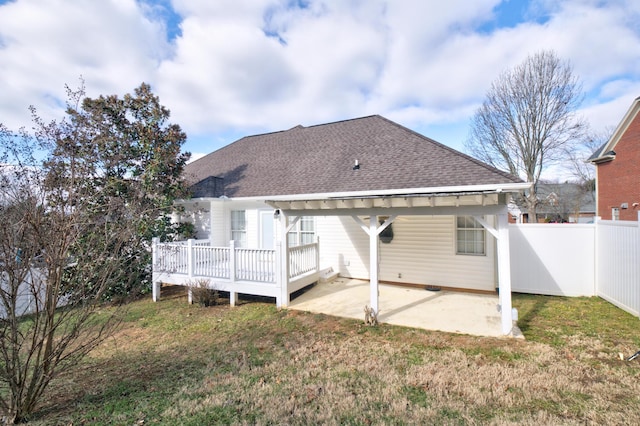 back of property with a yard, a patio area, and a wooden deck