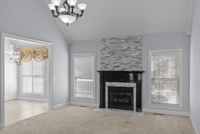 unfurnished living room featuring light carpet, high vaulted ceiling, a tile fireplace, an inviting chandelier, and crown molding