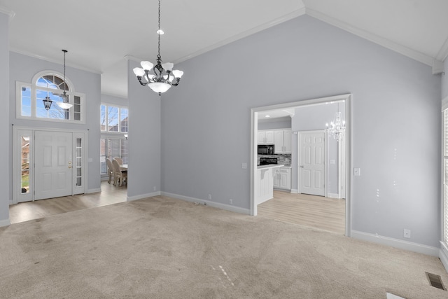 entrance foyer featuring a chandelier, light colored carpet, and crown molding