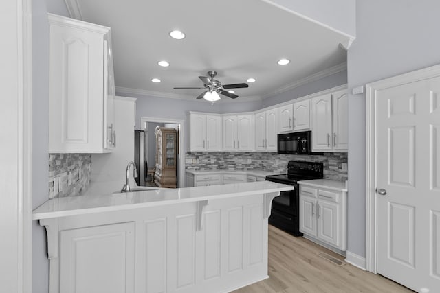 kitchen featuring kitchen peninsula, white cabinets, ceiling fan, and black appliances