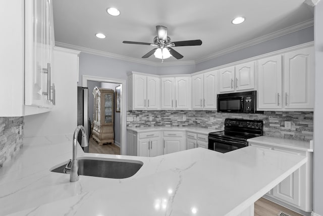 kitchen featuring black appliances, crown molding, sink, white cabinetry, and kitchen peninsula