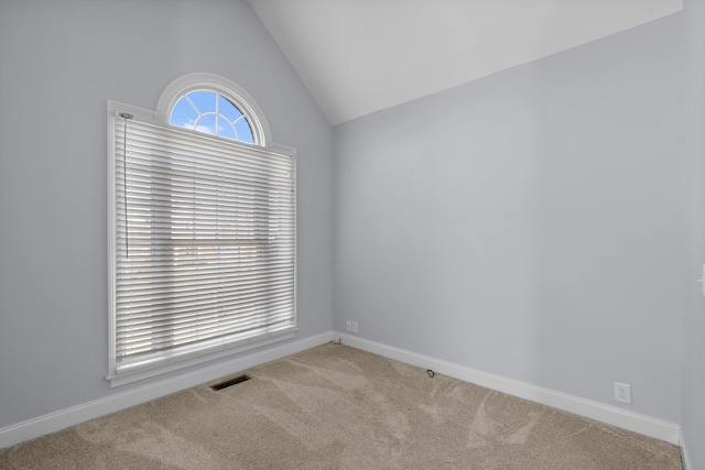 spare room with carpet and lofted ceiling