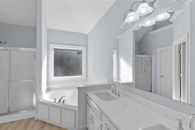 bathroom featuring a wealth of natural light, vanity, separate shower and tub, vaulted ceiling, and hardwood / wood-style floors