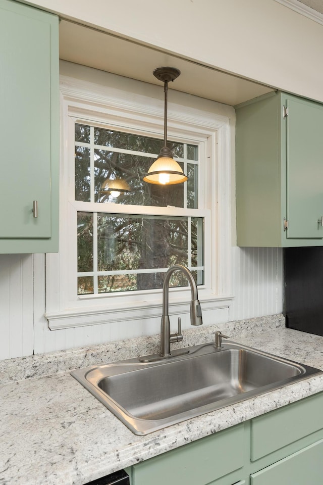 kitchen with sink, hanging light fixtures, and green cabinetry