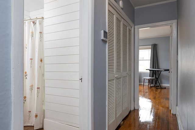 corridor featuring dark hardwood / wood-style flooring and ornamental molding