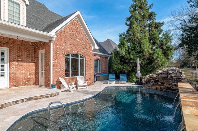 view of pool with pool water feature and a patio