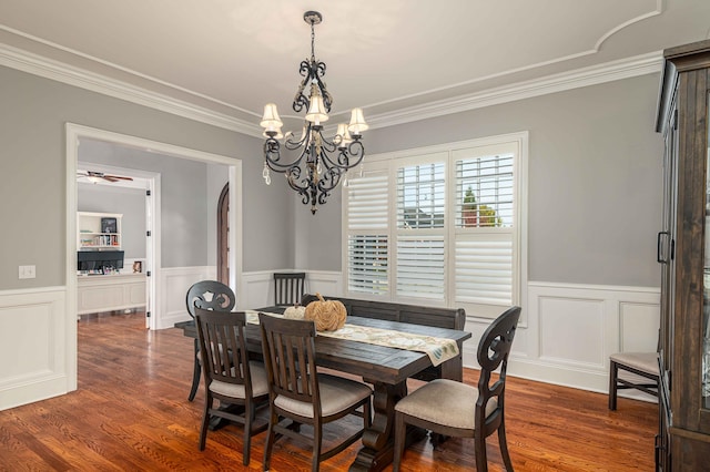 dining space with ceiling fan with notable chandelier, dark wood-type flooring, and ornamental molding