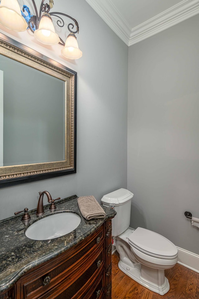 bathroom with wood-type flooring, vanity, toilet, and ornamental molding