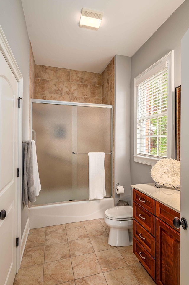 full bathroom with tile patterned flooring, vanity, toilet, and enclosed tub / shower combo