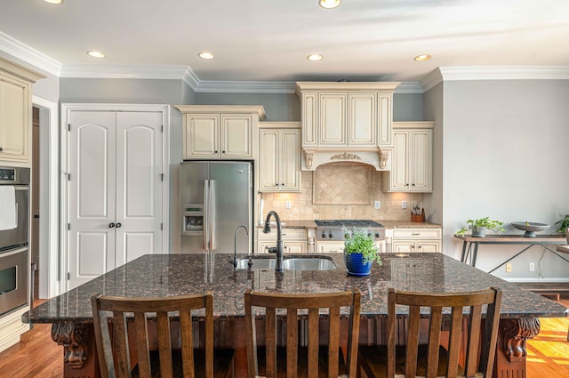 kitchen featuring cream cabinetry, appliances with stainless steel finishes, a spacious island, and sink