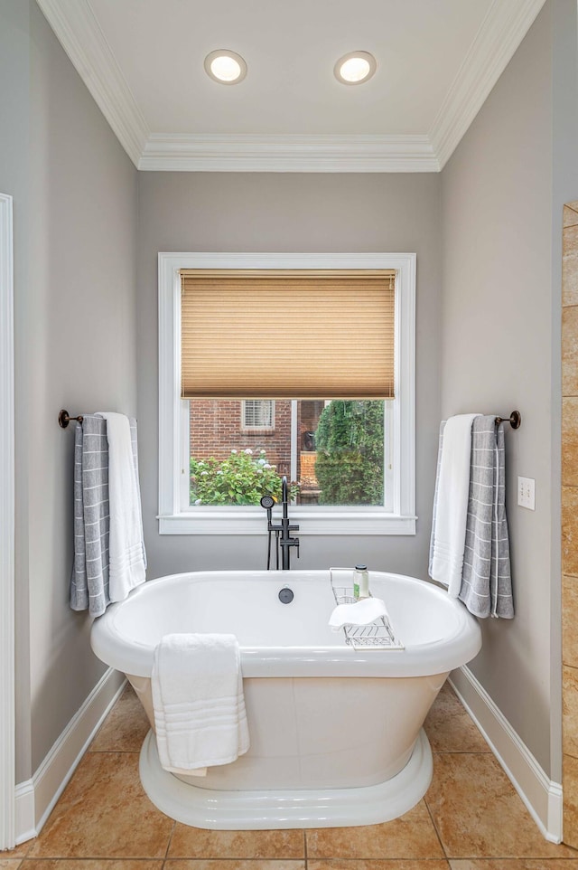 bathroom featuring tile patterned flooring, a washtub, and crown molding