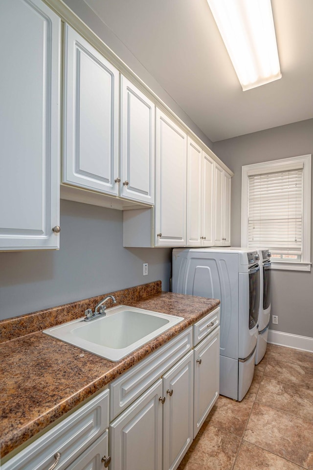 laundry room featuring cabinets, washer and clothes dryer, and sink