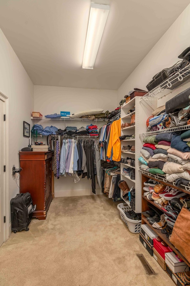 walk in closet featuring light carpet