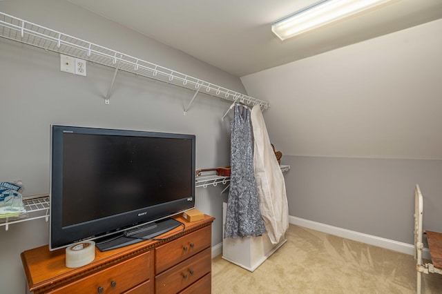 spacious closet featuring lofted ceiling and light carpet