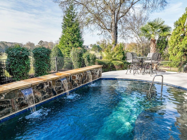 view of pool with pool water feature and a patio