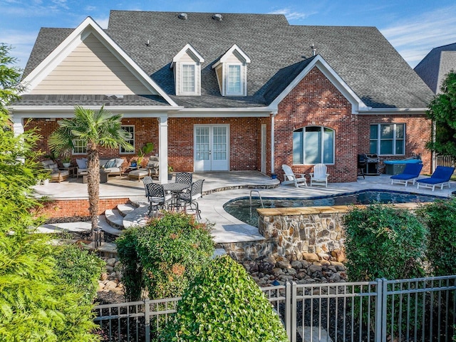 back of property featuring outdoor lounge area, a fenced in pool, a patio, and french doors