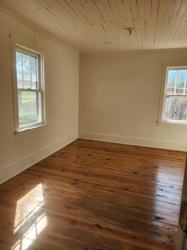 spare room with plenty of natural light, crown molding, wooden ceiling, and dark wood-type flooring