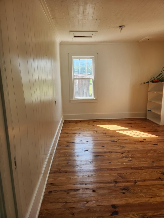 empty room featuring hardwood / wood-style flooring and crown molding