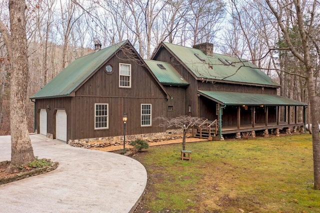 view of property exterior with a yard, covered porch, and a garage