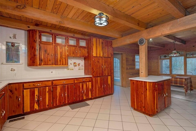 kitchen with wood ceiling, beam ceiling, light tile patterned floors, hanging light fixtures, and wood walls