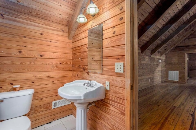 bathroom featuring lofted ceiling with beams, wood ceiling, and wooden walls