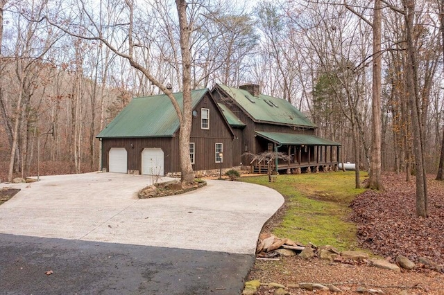 view of front of home with a wooden deck, a front lawn, and a garage