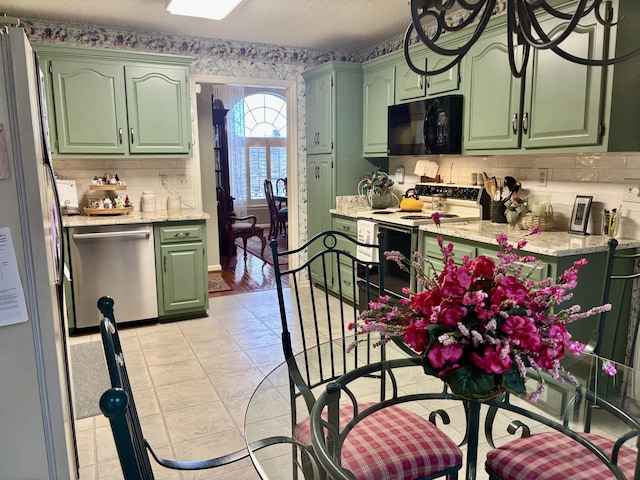 kitchen featuring light tile patterned floors, white appliances, green cabinets, and light stone counters