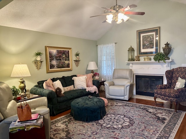 living room with wood-type flooring, a textured ceiling, ceiling fan, and vaulted ceiling