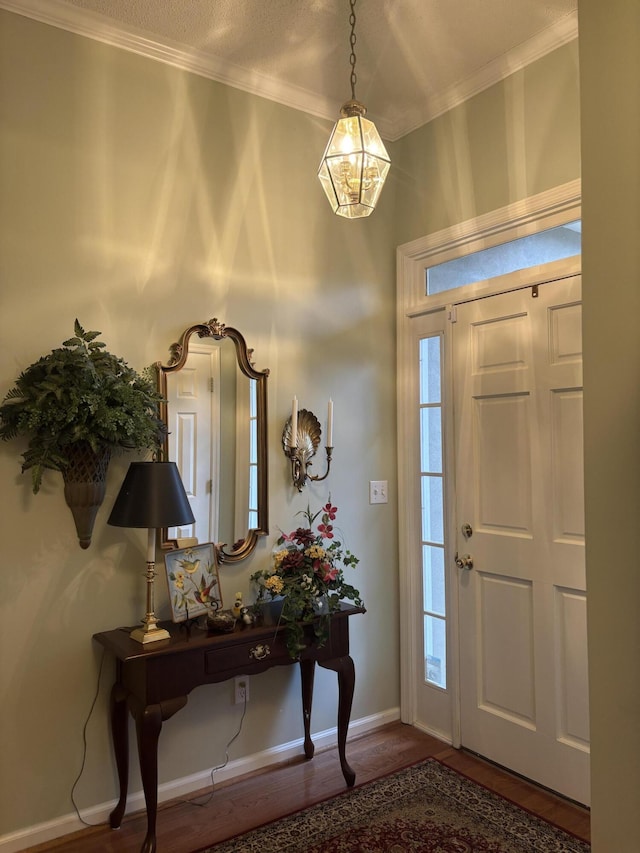 entrance foyer with ornamental molding and hardwood / wood-style floors