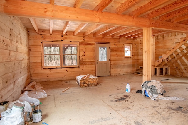 miscellaneous room featuring wood walls and beam ceiling