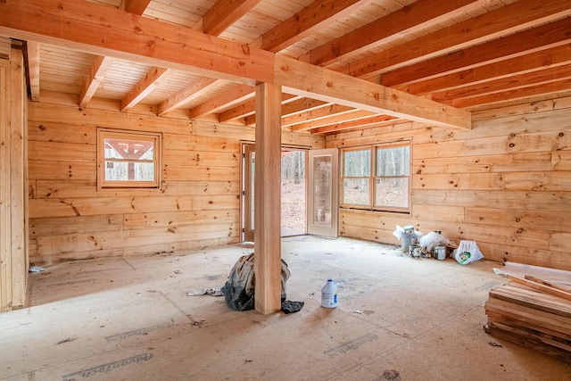 spare room featuring wooden walls and beamed ceiling