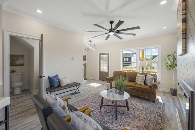 living room featuring ceiling fan, plenty of natural light, ornamental molding, and hardwood / wood-style flooring