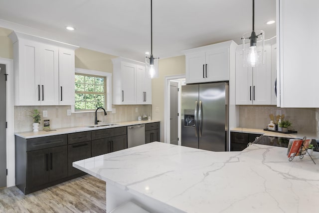 kitchen featuring white cabinetry, sink, pendant lighting, and appliances with stainless steel finishes