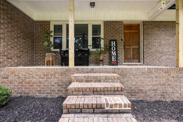 view of exterior entry featuring covered porch and french doors