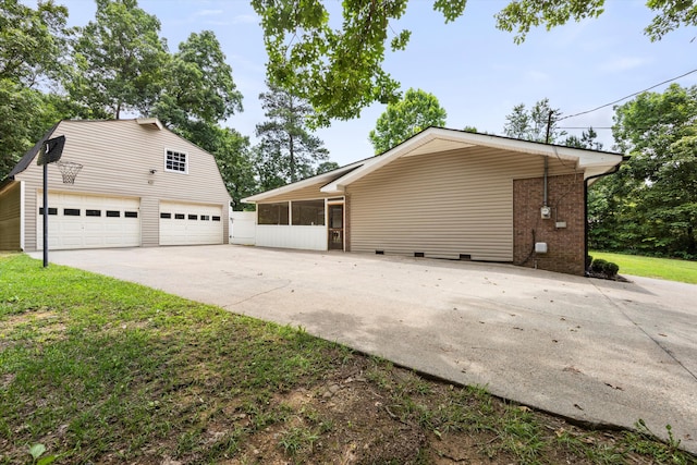 view of side of home with a lawn, a sunroom, and a garage