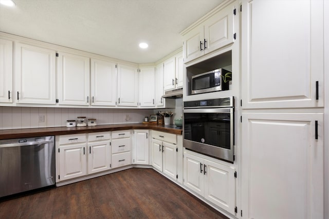 kitchen featuring wood counters, white cabinetry, dark wood-type flooring, and appliances with stainless steel finishes