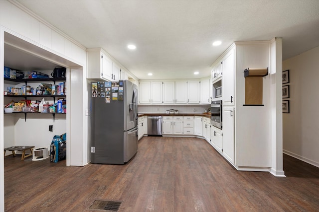 kitchen featuring white cabinetry, dark hardwood / wood-style flooring, and appliances with stainless steel finishes