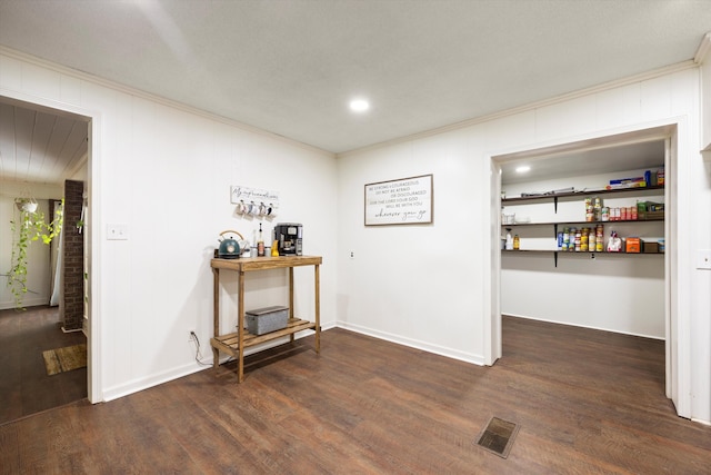 interior space with crown molding and dark hardwood / wood-style flooring