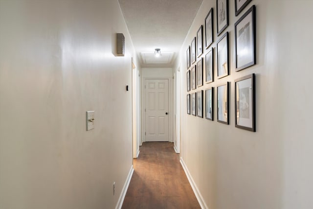 corridor with a textured ceiling and dark wood-type flooring