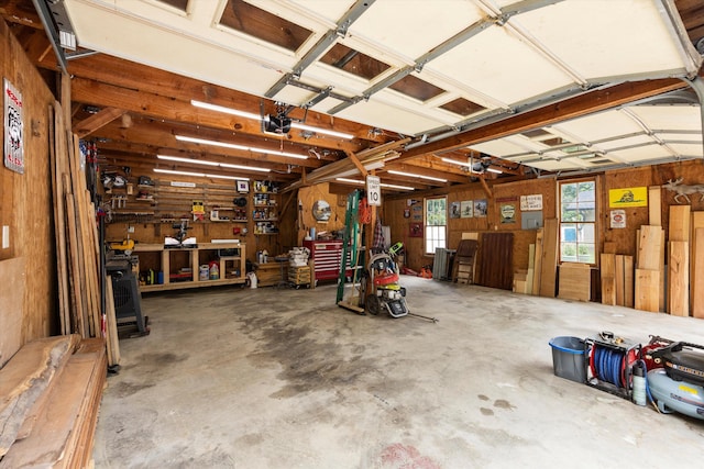 garage with a workshop area and wood walls