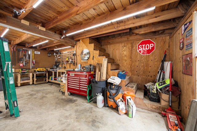 garage featuring a workshop area and wood walls