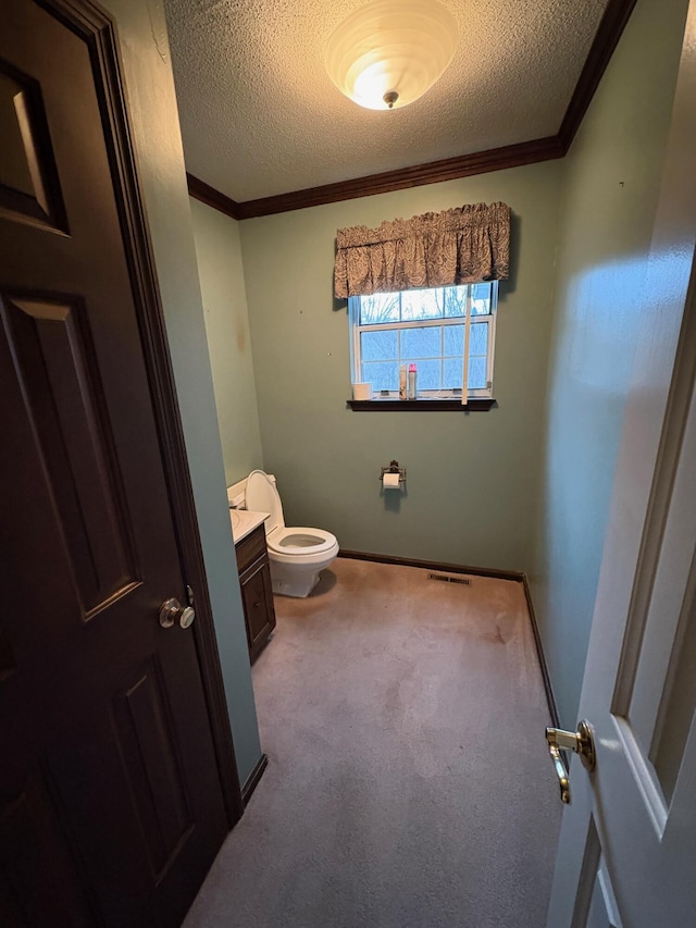 bathroom featuring vanity, toilet, a textured ceiling, and crown molding