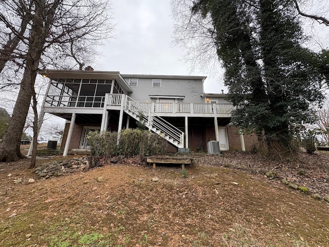 back of property with a sunroom, a deck, and central air condition unit