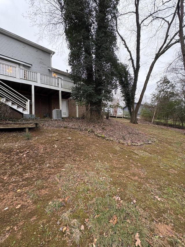 view of yard with central AC unit and a deck